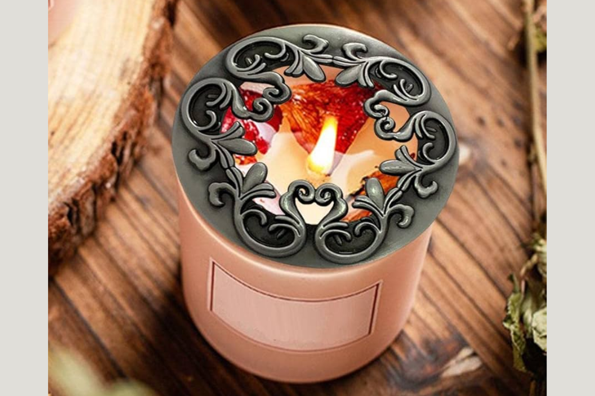 Unattractive candle topper with a lit candle on a wooden surface